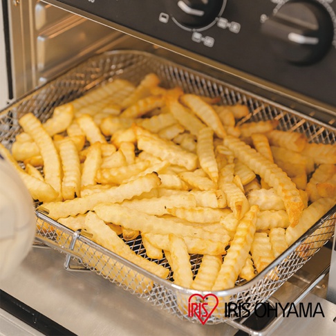 23L大容量氣炸烤箱 FVX-D18A 內部，裝滿了金黃色的波浪切薯條，薯條放在金屬網籃中，烤箱內部的黑色控制面板和銀色烤架清晰可見。