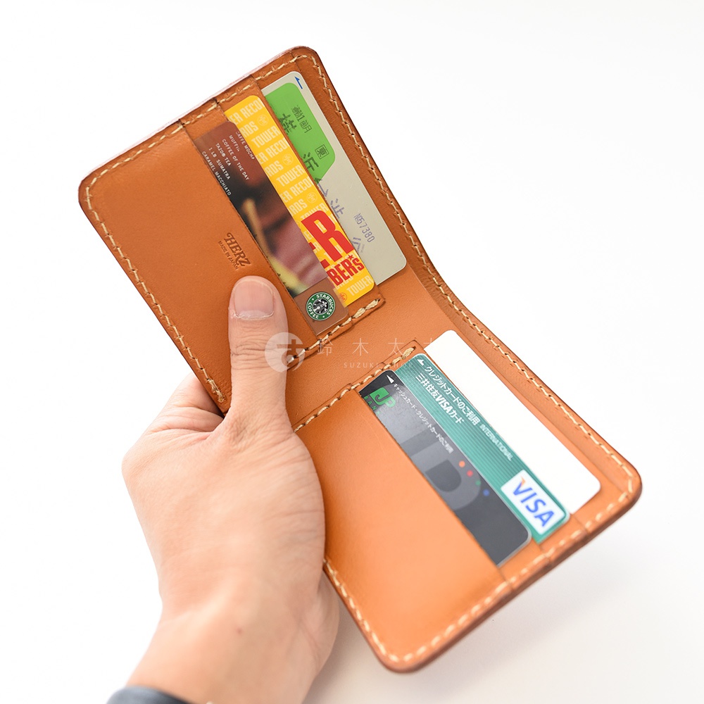 職人手作皮革二折橫式卡片紙鈔小短夾，採用淺棕色皮革製作，內含多個卡槽，可放入信用卡、紙鈔及證件，縫線整齊，展現細緻工藝。