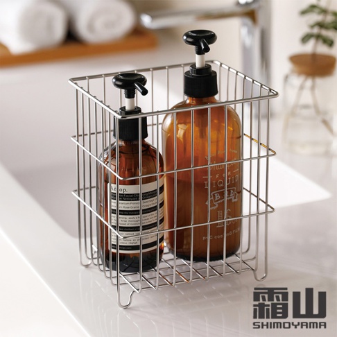 一個小款復古風304不鏽鋼置物收納籃，內有兩瓶琥珀色玻璃瓶裝的洗手液或沐浴乳，籃子採用細緻的金屬線條編織而成，呈現簡約的銀色金屬質感。