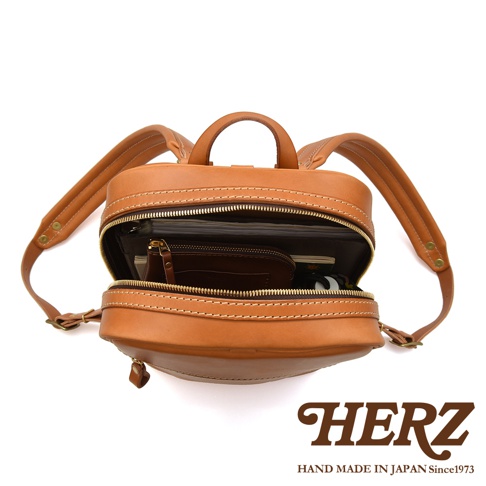 職人手作皮革長方型多口袋後背包 R-17，展示為棕褐色皮革材質，包身結構清晰，拉鍊全開露出內部空間，可見多層文件與一個小皮夾，雙肩帶設計，整體呈現簡約風格。