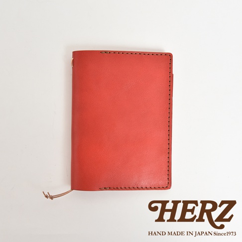 紅色皮革手帳書套，附有縫線細節和綁帶，右下角有HERZ品牌標誌。