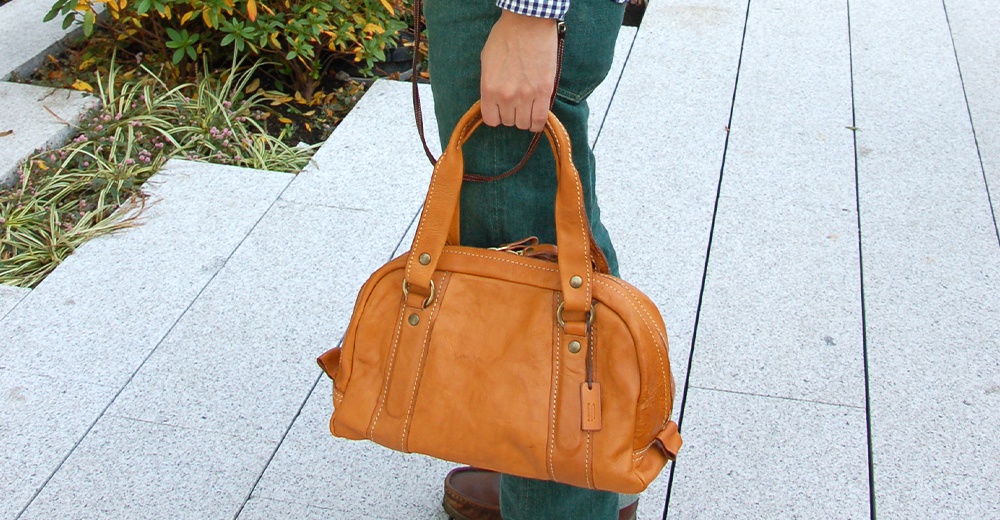 棕褐色皮革迷你波士頓包，雙提把，附有可拆卸長背帶，包身有精緻縫線及金屬配件，另有同色皮革吊牌。