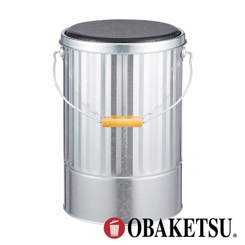 OBAKETSU 品牌的手工製金屬儲物桶，頂部帶有黑色軟墊，可用作凳子，側面有木製提手。