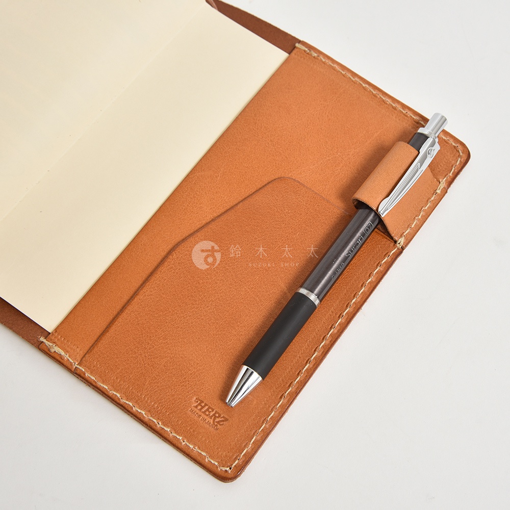 職人手作皮革手帳書套，附一支筆，皮革顏色為棕色，有縫線細節。