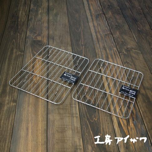 兩個方形不鏽鋼瀝油架，均為銀色金屬網格結構，其中一個標籤顯示尺寸為 21x16.5x10 公分。