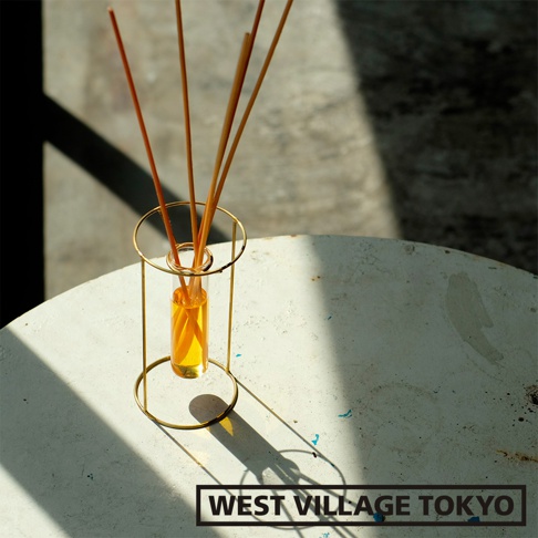 圓柱形黃銅支架，內置透明玻璃管，裝有琥珀色液體和散香竹籤。