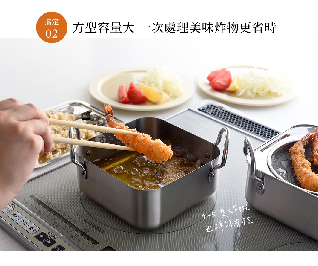 逸品物創不鏽鋼方型炸物鍋組，鍋身為銀色不鏽鋼材質，配有雙耳把手。鍋中油炸著金黃色的炸蝦，一旁有濾網。另有兩個盤子，裝有切碎的蔬菜、番茄塊和檸檬片。