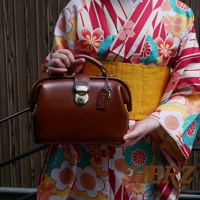 職人手作皮革方型迷你醫生包，經典棕色，採用光滑皮革材質，配有金屬旋轉鎖扣和鑰匙吊飾。