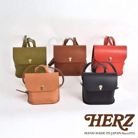 五款職人手作皮革翻蓋迷你後背包，顏色包含：卡其綠、棕色、橘棕色、紅色、黑色。皆為皮革材質，設計簡約，配有金色旋轉鎖扣。