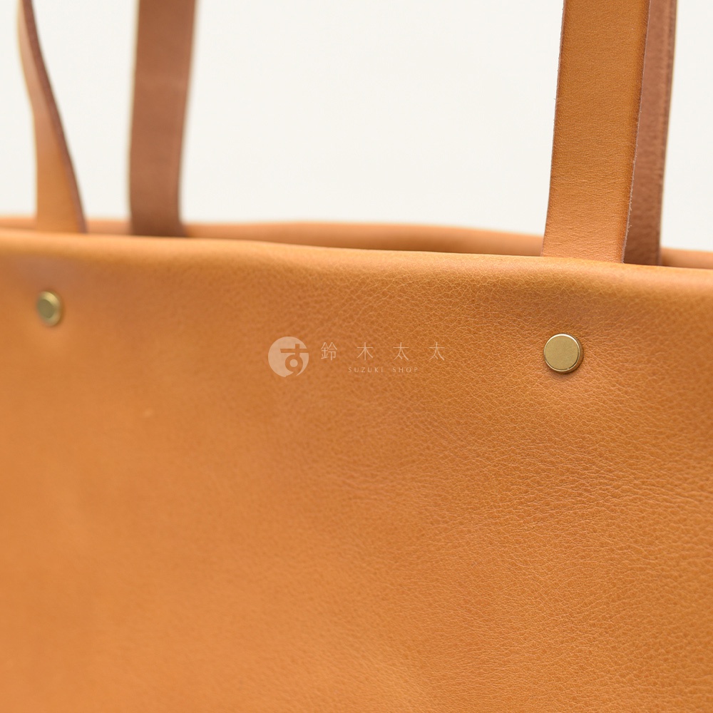 職人手作皮革托特包，淺棕色，設有兩個金屬鉚釘和皮革提把。