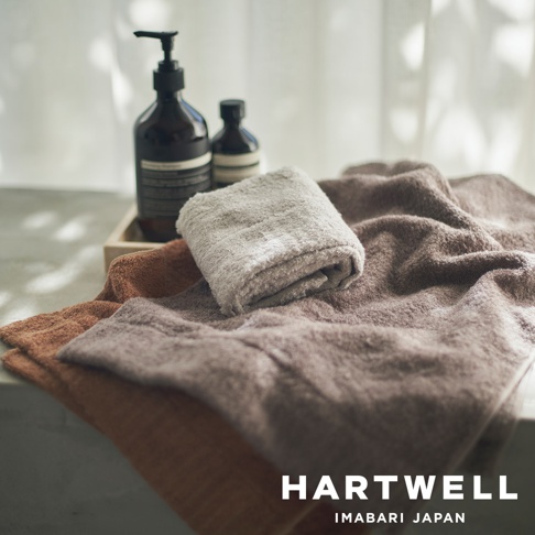 三條CUOL今治柔彈美髮毛巾，顏色包含棕色、淺棕色和灰色，材質柔軟。