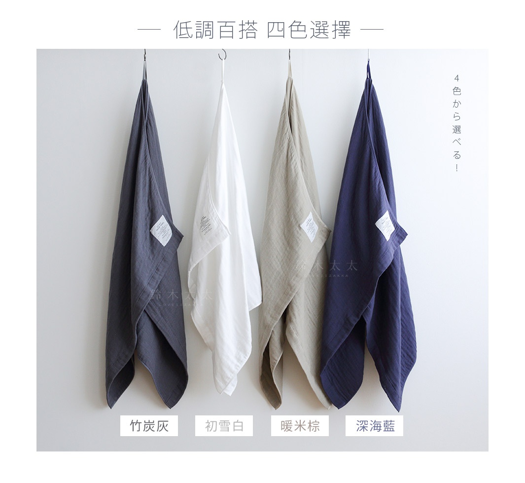 四條2.5層紗浴巾，分別為竹炭灰、初雪白、暖米棕及深海藍，皆為M尺寸，垂掛於牆上。