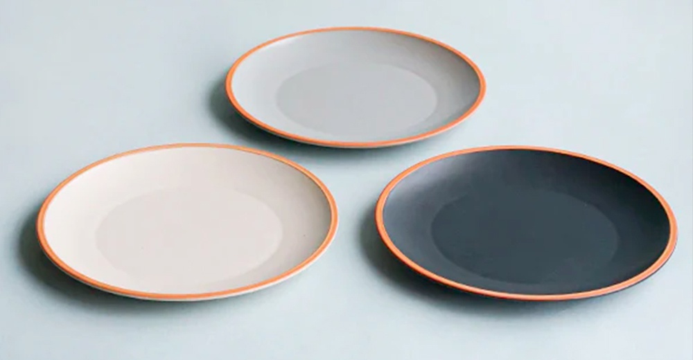 PURE 素燒百搭陶瓷主菜盤 M，共三色：淺灰、米白、深灰。盤子為圓形，邊緣飾有橘色滾邊，材質為陶瓷。