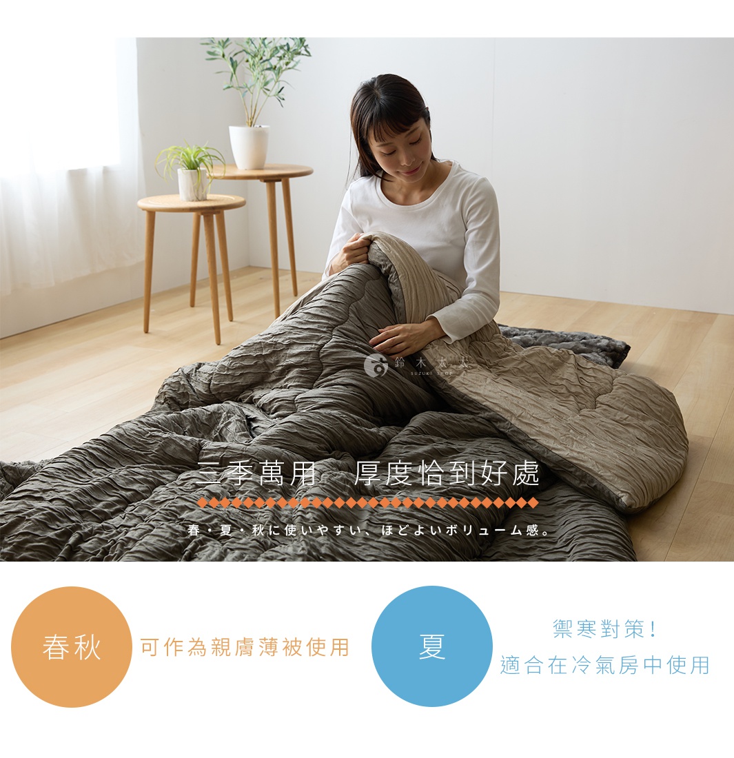 一位女子坐在木質地板上，將柔軟的灰色皺褶材質單人被鋪開。圖片標題強調此款被子適合春秋季使用，厚度適中，且在夏季冷氣房中也能當作薄被禦寒使用，展現多功能的居家實用性。