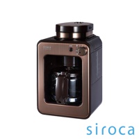 銅色與黑色相間的 SC-A1210 自動研磨咖啡機，設有玻璃咖啡壺、操作按鈕及旋鈕，頂部有研磨器蓋。