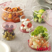 多個透明耐熱玻璃圓形保鮮盒，裝有不同食材，如蔬菜、水果、起司和海鮮，底部和蓋子邊緣為粉紅色。