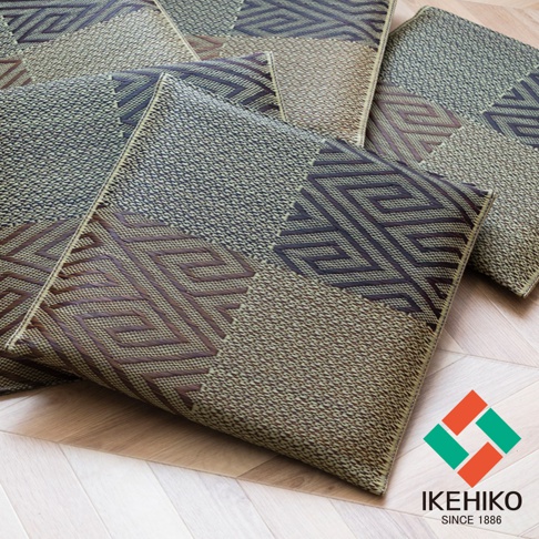 數個天然和風藺草紋織坐墊，以大地色系與深棕色為主，交織出幾何圖案和細緻紋理，鋪設於淺木色地板上。