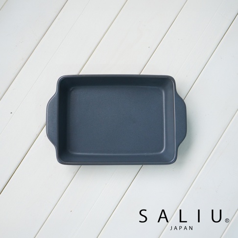 一個深灰色、平底、帶有兩個短邊把手的陶製長方形烤盤，放置在白色木紋背景上。