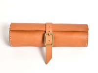 職人手作皮革捲捲收納筆袋 (KP-100)，原色皮革，附有古銅色針扣皮帶固定，邊緣縫線清晰。