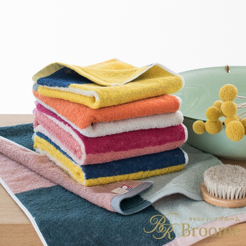 一疊純棉毛巾，呈現玩轉色塊的混色設計，包含黃色、橘色、粉色、紫紅色、藍色與綠色等，質感柔軟。