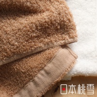 兩條深棕色絨毛毛巾，其中一條有米色滾邊，疊放在白色絨毛毛巾上。