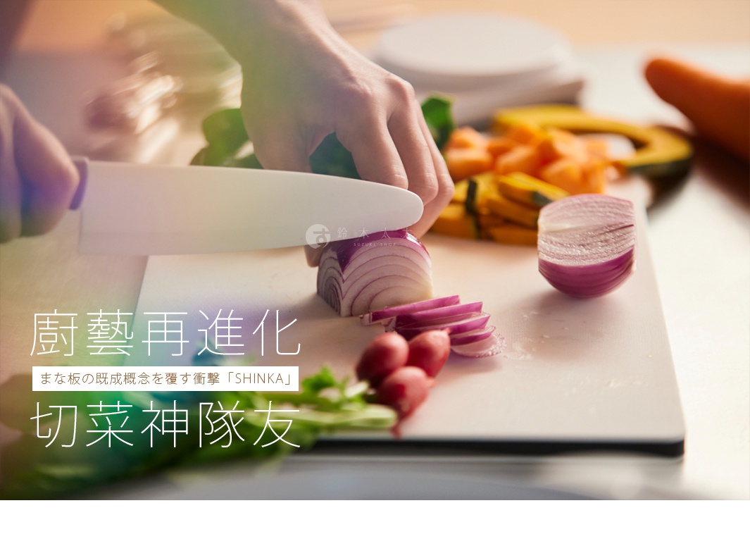 白色抗菌耐熱砧板上，手持白色刀具正在切紫洋蔥，旁邊擺放著其他蔬菜，如紅蘿蔔、櫛瓜和櫻桃蘿蔔。