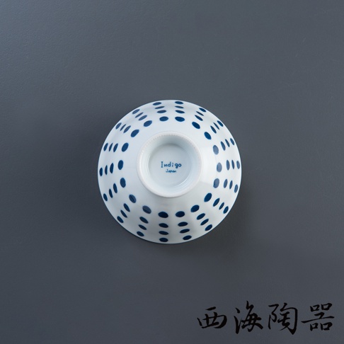 白色陶瓷飯碗，碗身外觀佈滿藍色圓點紋飾，碗底中央有「Indigo Japan」字樣。