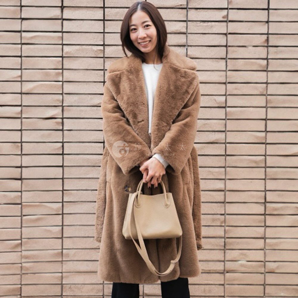 一位女子手持米色皮革兩用手提托特包，包款簡約，附有可拆卸斜背帶。