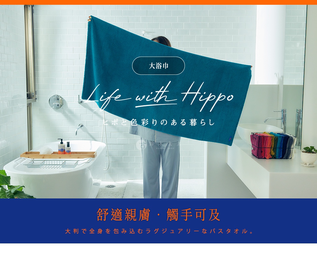 展示一條藍綠色厚實大浴巾，由竹棉混紡製成，在浴室場景中被展開。旁邊的架子上擺放著一籃色彩鮮豔的毛巾。