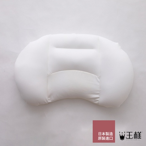 白色柔軟的舒肩枕，設計成流線型，中央有縫線分隔，下方有弧形凹槽，材質看起來像絲綢。