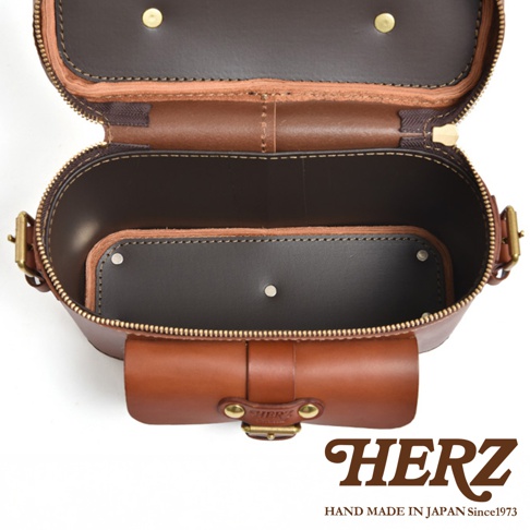 HERZ 職人手作皮革厚實相機包 N-8，展示包包打開後的內部結構，可見深棕色皮革內裡及隔層，並有品牌標誌。