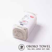 白色包裝內的淺米色髮用毛巾，材質為純棉，質感蓬鬆柔軟，適合用於頭髮護理。