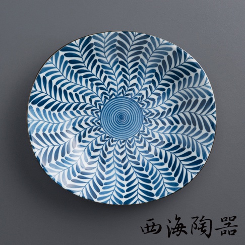波佐見燒職人手繪系列五件式淺菜盤，圓形陶瓷盤，中央為藍色螺旋紋飾，向外放射狀延伸著藍色手繪葉片圖案，盤緣飾有細緻的藍色線條。
