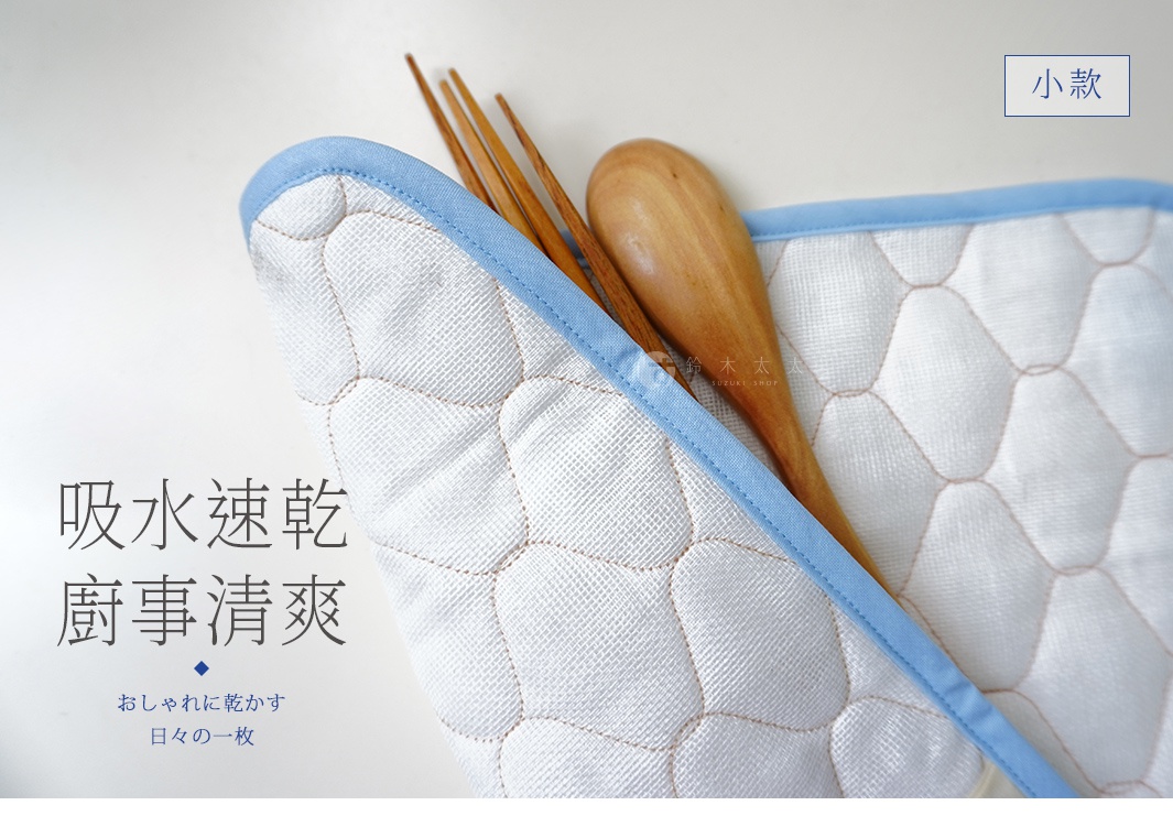 白色兩層蚊帳棉織廚房吸水墊，邊緣為淺藍色滾邊，表面有菱格紋車縫，墊內有木製湯匙和叉子。