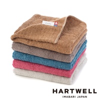 堆疊的 CUOL 今治柔彈低摩擦美髮半浴巾，展示棕褐色、灰色、藍色、粉紅色和淺灰色等顏色，材質觸感柔軟。