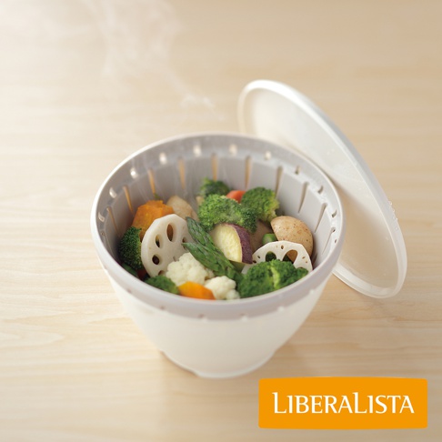 LIBERALISTA 品牌的多用途可微波耐熱瀝水籃組，內含多種蒸煮蔬菜，如花椰菜、紅蘿蔔、馬鈴薯、蓮藕和蘆筍，蒸氣正從籃中冒出。