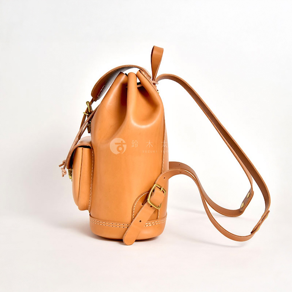 職人手作經典後背包 R-4，採用天然皮革製作，呈現溫潤的淺棕色。設計簡約，束口式開闔，配有側邊小口袋，搭扣和揹帶皆為皮革材質，整體質感樸實耐用。