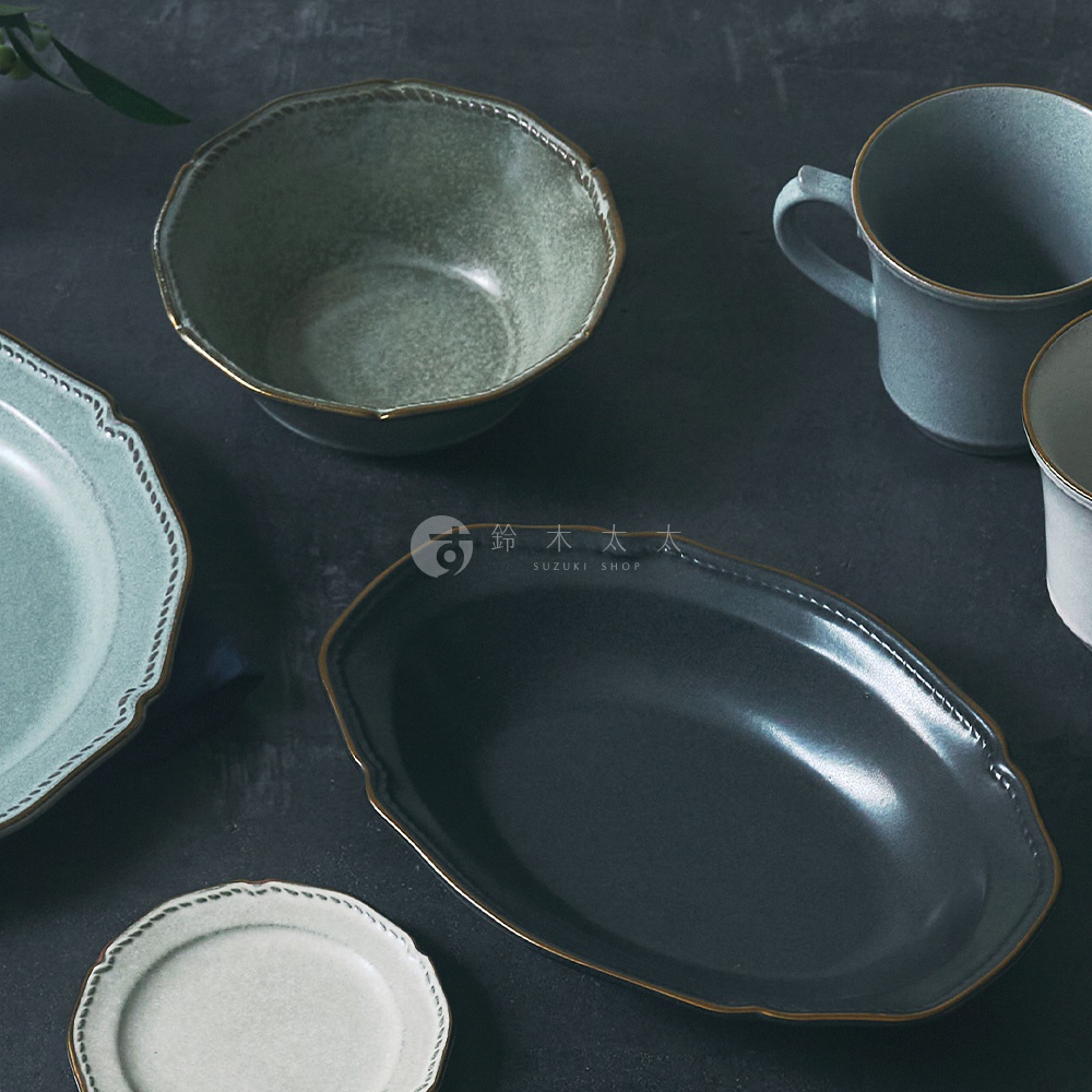AITO 品牌 Stitch 系列，日本美濃燒金彩浮雕復古湯碗，呈現在灰色桌面上的特寫畫面，碗盤邊緣帶有精緻的縫線浮雕與金色彩飾，營造古典雅致的餐桌氛圍
