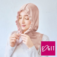 淺粉色絲質柔順的睡帽，帶有荷葉邊裝飾，由一位女性佩戴，她正用雙手調整睡帽。