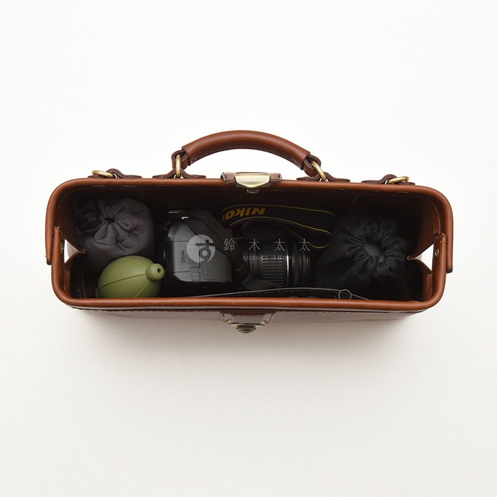 駝色皮革杜勒斯包，內含相機、鏡頭、鏡頭清潔氣吹和兩個收納袋