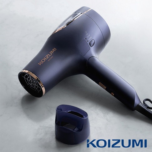 深藍色金屬飾邊的 KOIZUMI 雙渦輪負離子吹風機 KHD-G903-AE，配有兩個風速設定按鈕和一個冷風按鈕。產品旁邊有一個同款深藍色的配件。