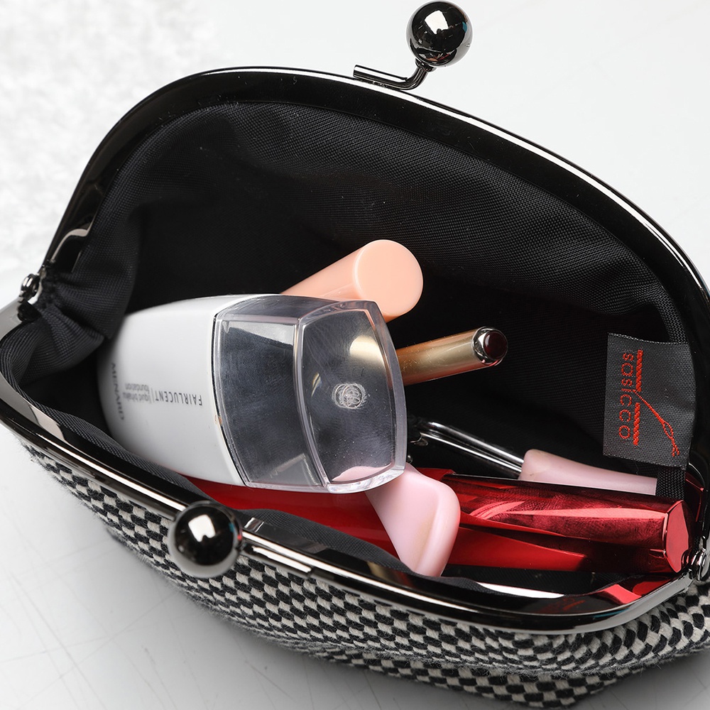 三河木綿刺子織口金零錢包，外觀為黑白格紋，內部裝有化妝品，如粉底、口紅及其他小物。