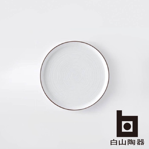 白磁千段圓盤，表面有同心圓紋理，邊緣帶有褐色細線，材質為陶瓷。