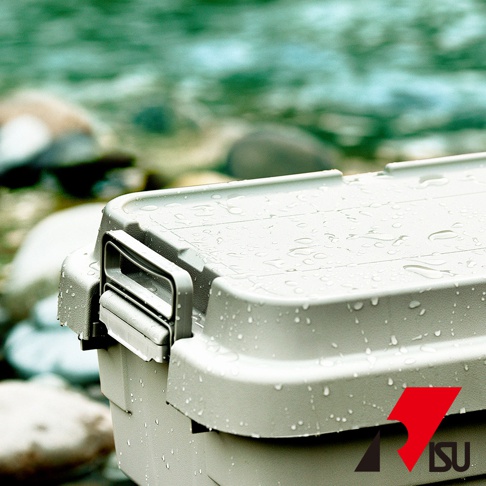 淺灰色塑膠製可堆疊多功能收納箱，箱蓋有水珠，左側有灰色提把，背景為溪流與岩石。