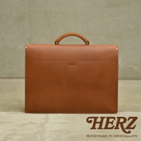 職人手作皮革Organ兩用商務公事包，採用棕色皮革製成，帶有頂部提把和金屬扣件，正面中央有「Organ」燙金字樣。