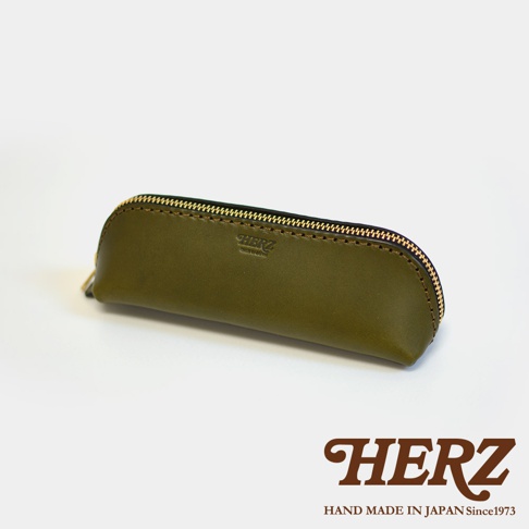 橄欖綠皮革三角筆袋，金色拉鍊，袋面上壓印有品牌標誌。