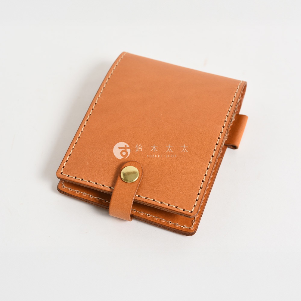 職人手作的淺棕色皮革便利貼收納套，採用精緻車縫線，配有金色按扣和皮革繫帶，方便收納。