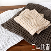 三條今治鬆餅毛巾疊放，分別為白色、淺米色與深棕色，皆具有蜂窩狀織紋，材質柔軟。