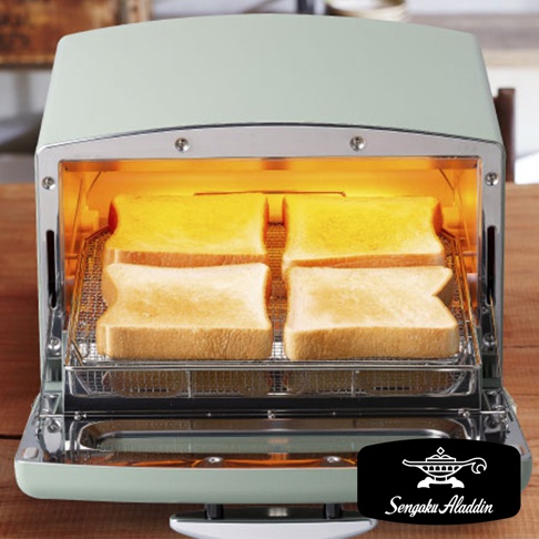 復古風格的淺綠色多用途烤箱，內部有四片吐司正在烘烤，吐司架為銀色金屬網格。