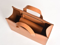 職人手作皮革直式隨行袋 (CP-9)，採用自然色調的皮革，袋身挺括，配有簡約的提把及內袋，整體呈現簡潔大方的風格。